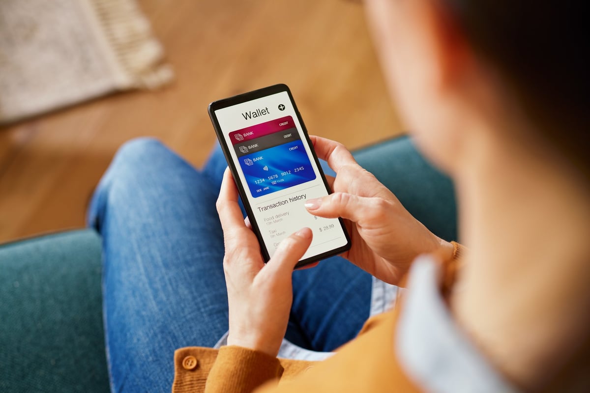 Woman using her smartphone to check her digital wallet balance and transaction history